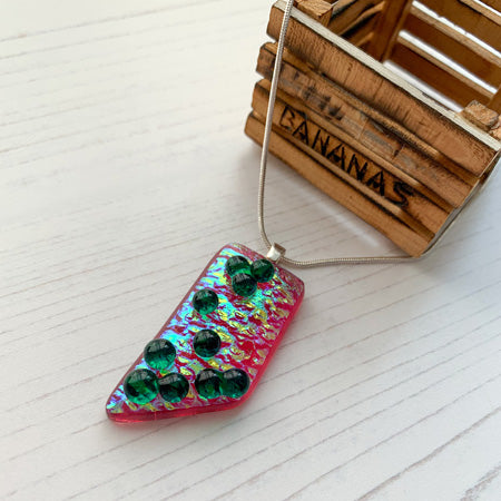 This pink green bubble dichroic glass necklace is a handmade necklace with translucent droplets on pink dichroic glass.