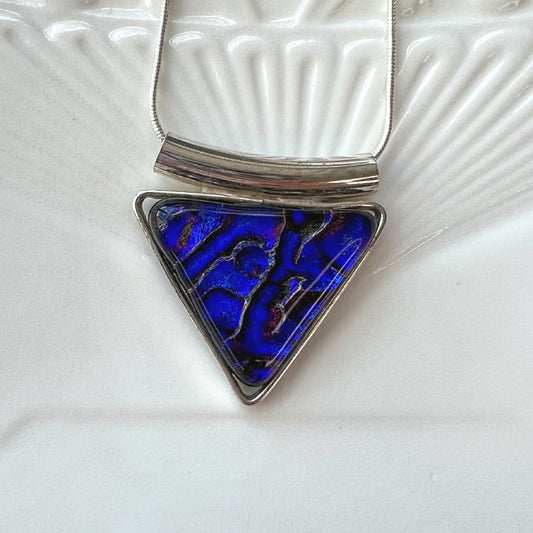 This geometric triangle dichroic glass necklace is a handmade necklace in colourful geometric patterns.