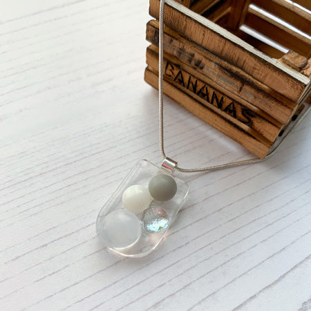 This light monochrome bubble glass necklace is a handmade necklace with multicoloured droplets on a bed of clear glass.