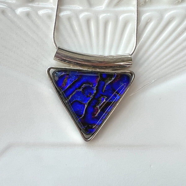 This geometric triangle dichroic glass necklace is a handmade necklace in colourful geometric patterns.