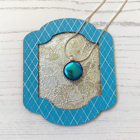 This round teal ingenue necklace is in dichroic glass. It is a handmade necklace inspired by the princess in all of us!
